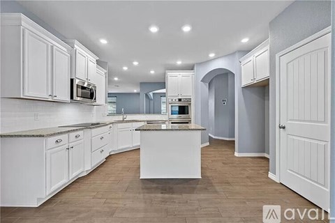 A kitchen with white cabinets and a central island.