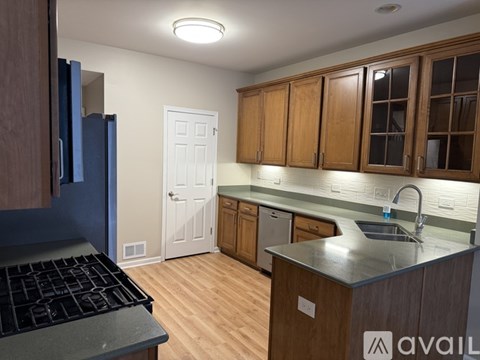A kitchen with wooden cabinets and a black stove top.