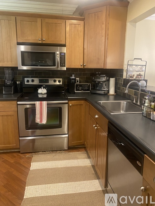 A kitchen with wooden cabinets and a black countertop.