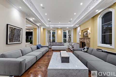 A spacious living room with a grey sofa set and a marble coffee table.