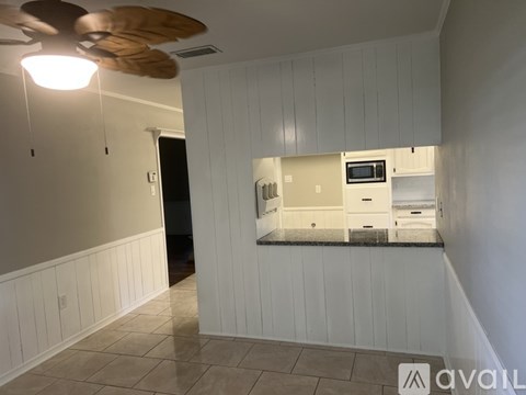 A kitchen with white cabinets and a black countertop.