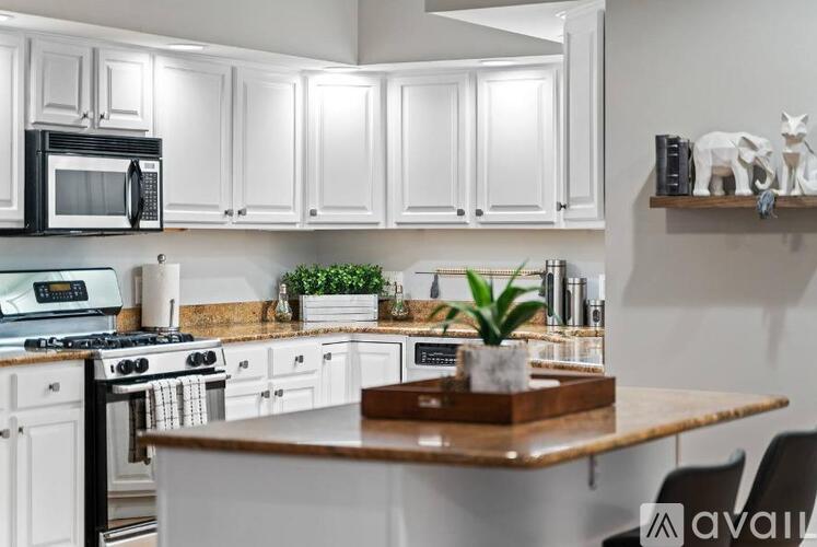A kitchen with white cabinets and a wooden island.