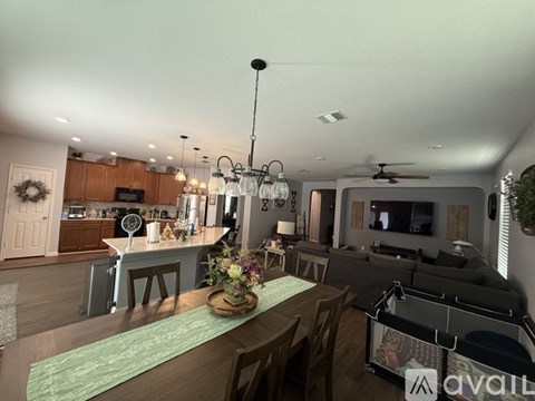 A well-lit, modern kitchen and living room with a dining table set for two.