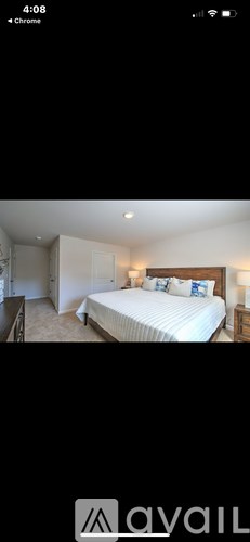 A bedroom with a large bed and a nightstand.