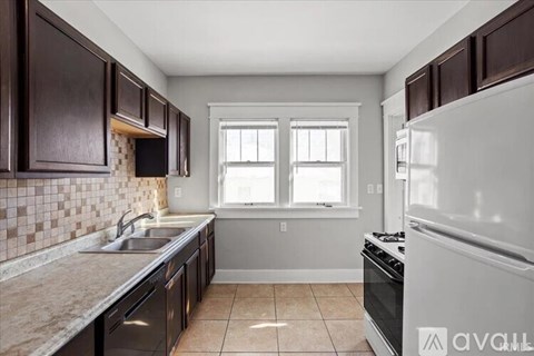 A kitchen with brown cabinets and a white refrigerator.