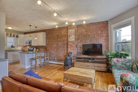 A living room with a brown leather couch and a wooden coffee table.