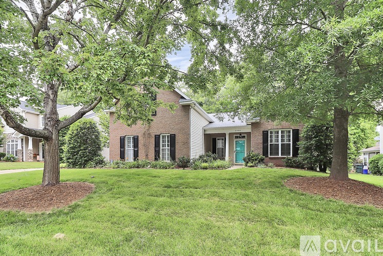 A house with a green door and a tree in front.