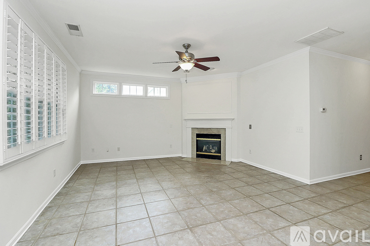 A living room with a fireplace and a ceiling fan.