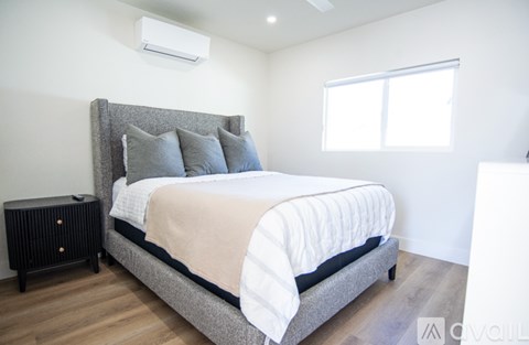 A bedroom with a large bed and a small black table.
