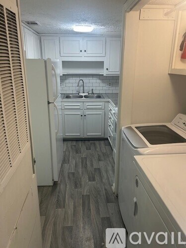A kitchen with white appliances and cabinets.