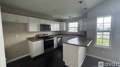 A kitchen with white cabinets and a brown countertop.