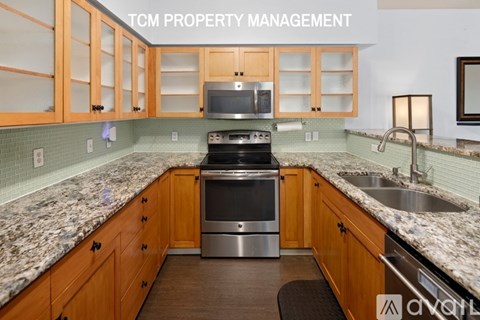A kitchen with wooden cabinets and a granite countertop.