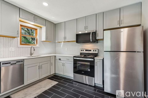A kitchen with a stainless steel refrigerator and a microwave above the stove.