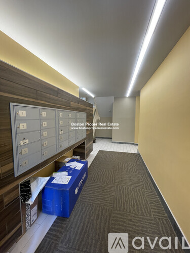 A hallway with a sign that says "Boston Proper Real Estate" and a website address.