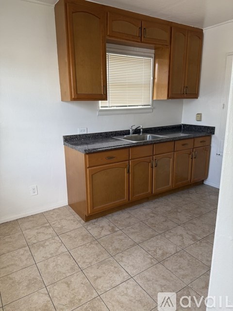 A kitchen with wooden cabinets and a black countertop.