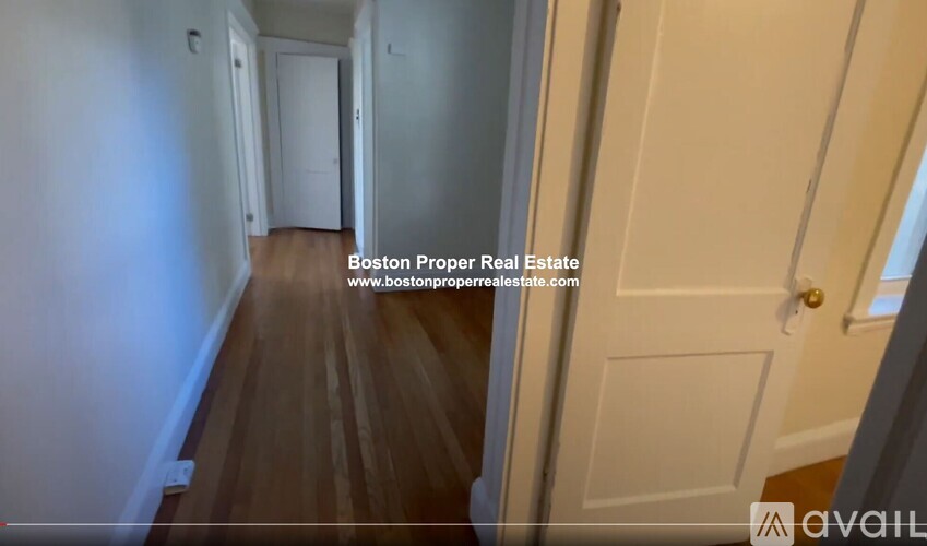 A hallway with a door on the right and a wall on the left.