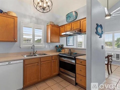 A kitchen with wooden cabinets and a white dishwasher.