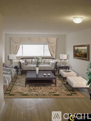 A living room with a couch, coffee table, and a painting on the wall.