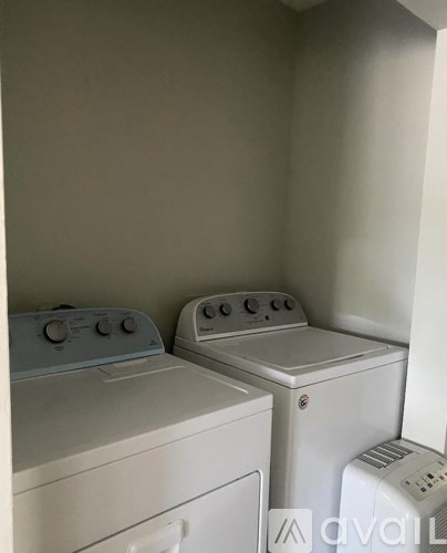 A washing machine and a dryer are in a small room.