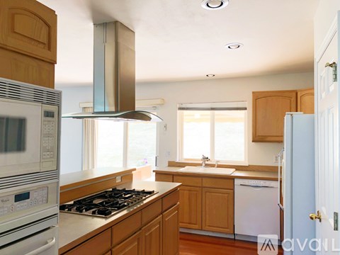 A kitchen with wooden cabinets and a white fridge.