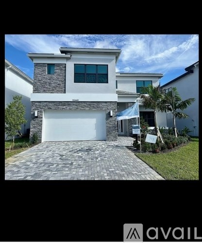 A modern house with a stone facade and a white garage door.