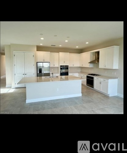A modern kitchen with white cabinets and appliances.