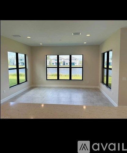 A spacious room with large windows and a marble floor.