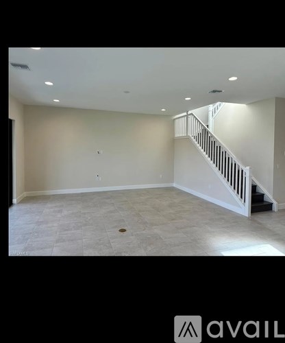 A spacious room with a staircase and tiled floor.