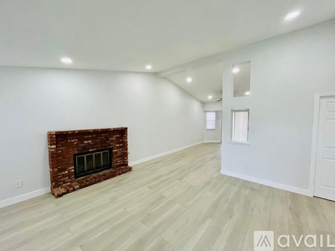 A room with a fireplace and wooden flooring.