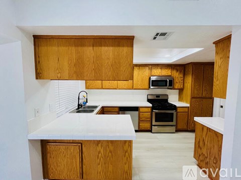 A kitchen with wooden cabinets and a white countertop.