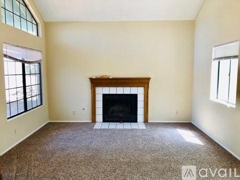 A living room with a fireplace and carpeting.