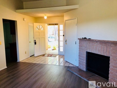 A living room with a fireplace and a door leading to a balcony.