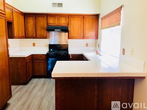 A kitchen with wooden cabinets and a black stove top oven.