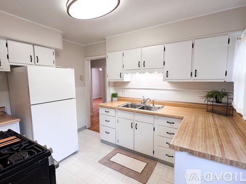 A kitchen with white cabinets and a black stove top oven.