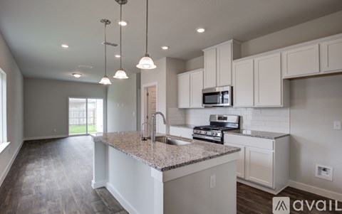 A kitchen with a granite countertop and white cabinets.