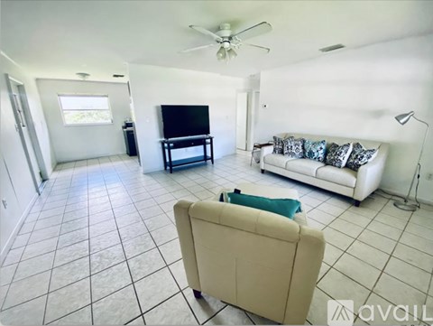 A living room with a beige couch and a television.