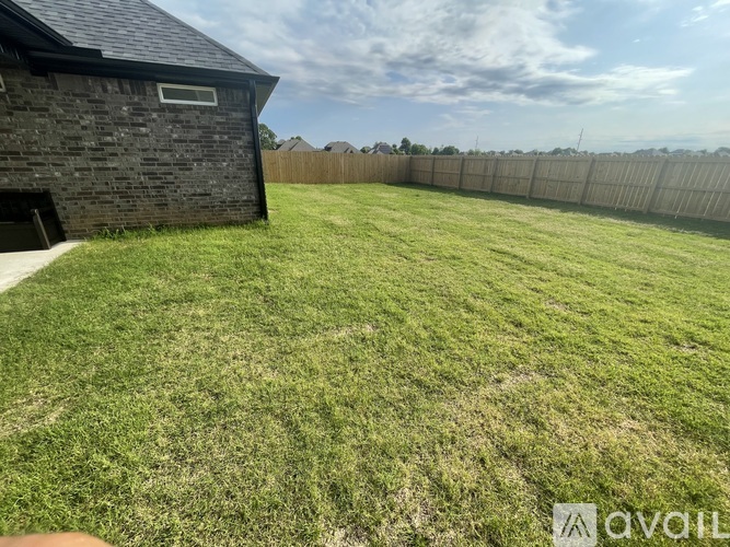 A backyard with a fence and a small building.