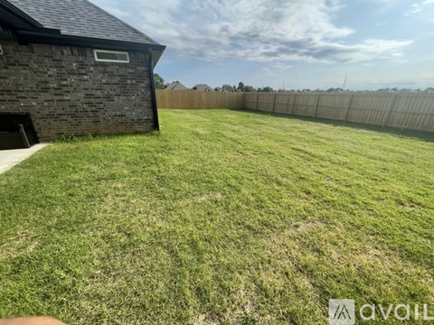 A backyard with a fence and a small building.