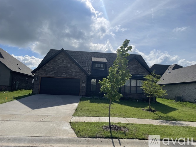 A house with a driveway and a tree in front.