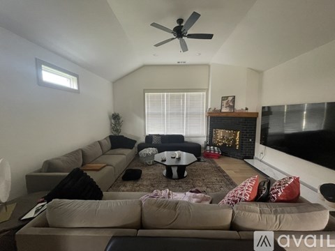 A living room with a large couch and a fireplace.