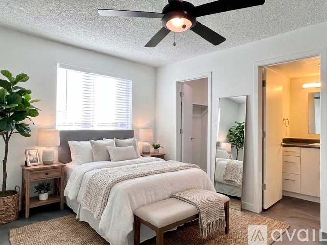 A bedroom with a large bed and a ceiling fan.