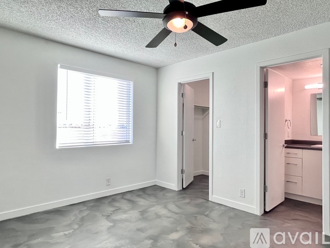 A room with a ceiling fan and a window with blinds.