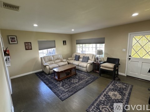 A living room with a white sofa and a black chair.