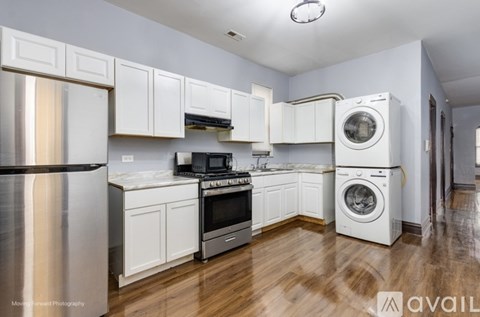 A kitchen with white cabinets and a wooden floor.