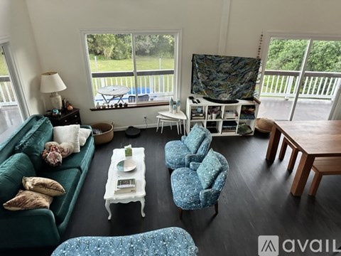A living room with a green couch and a white coffee table.
