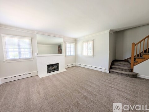 A living room with a fireplace and two windows.