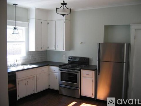 A kitchen with white cabinets and a stainless steel refrigerator.