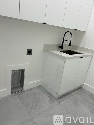A kitchen with a sink and a drain in the floor.