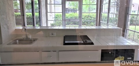 A kitchen with a sink and a window overlooking a garden.