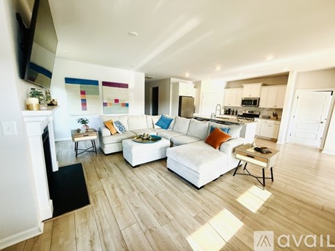 A living room with a white couch and a television on the wall.